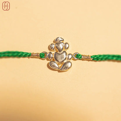 Ganesh Ji face silver rakhi online with detailed silver Ganesh charm and green thread by Hardik Jewels