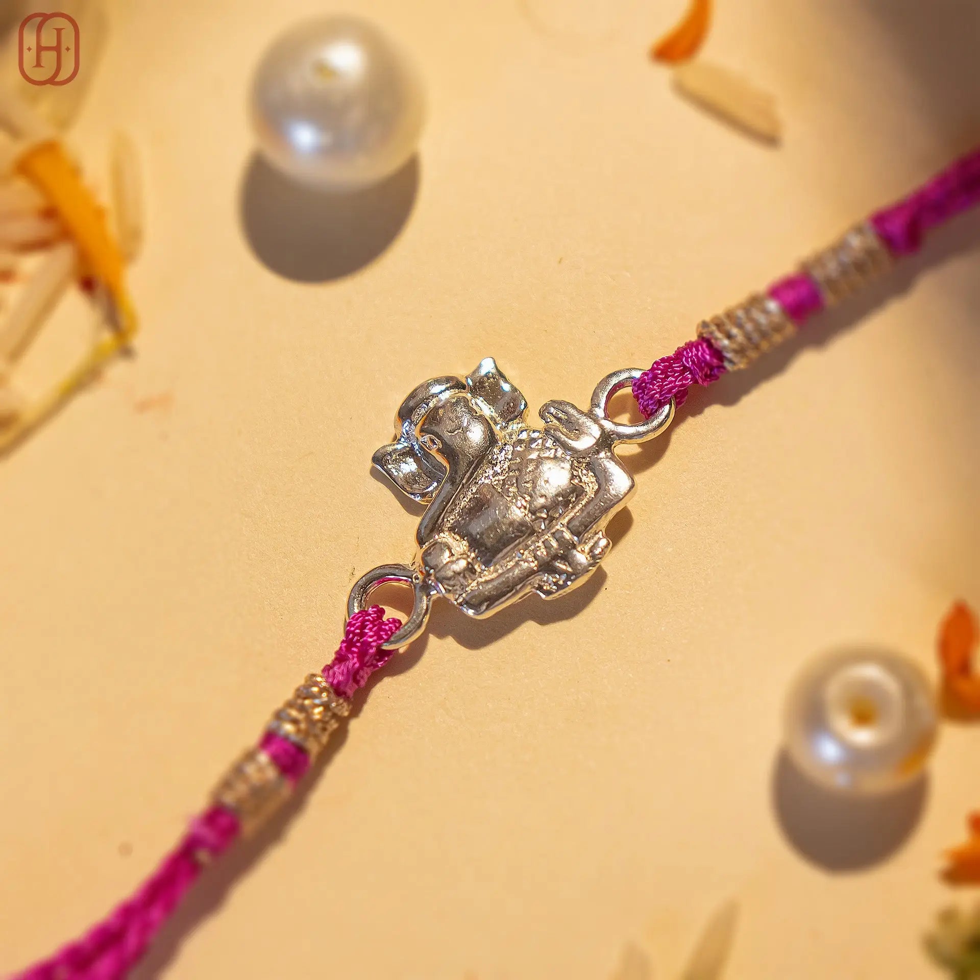 Ganesh Ji face rakhi in silver with detailed elephant design and purple thread by Hardik Jewels