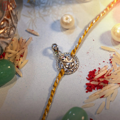 Ganesh Ji fine silver rakhi with filigree ball charm on golden thread - Hardik Jewels
