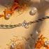 Ganesh silver rakhi with intricate elephant charm and braided green and white thread by Hardik Jewels