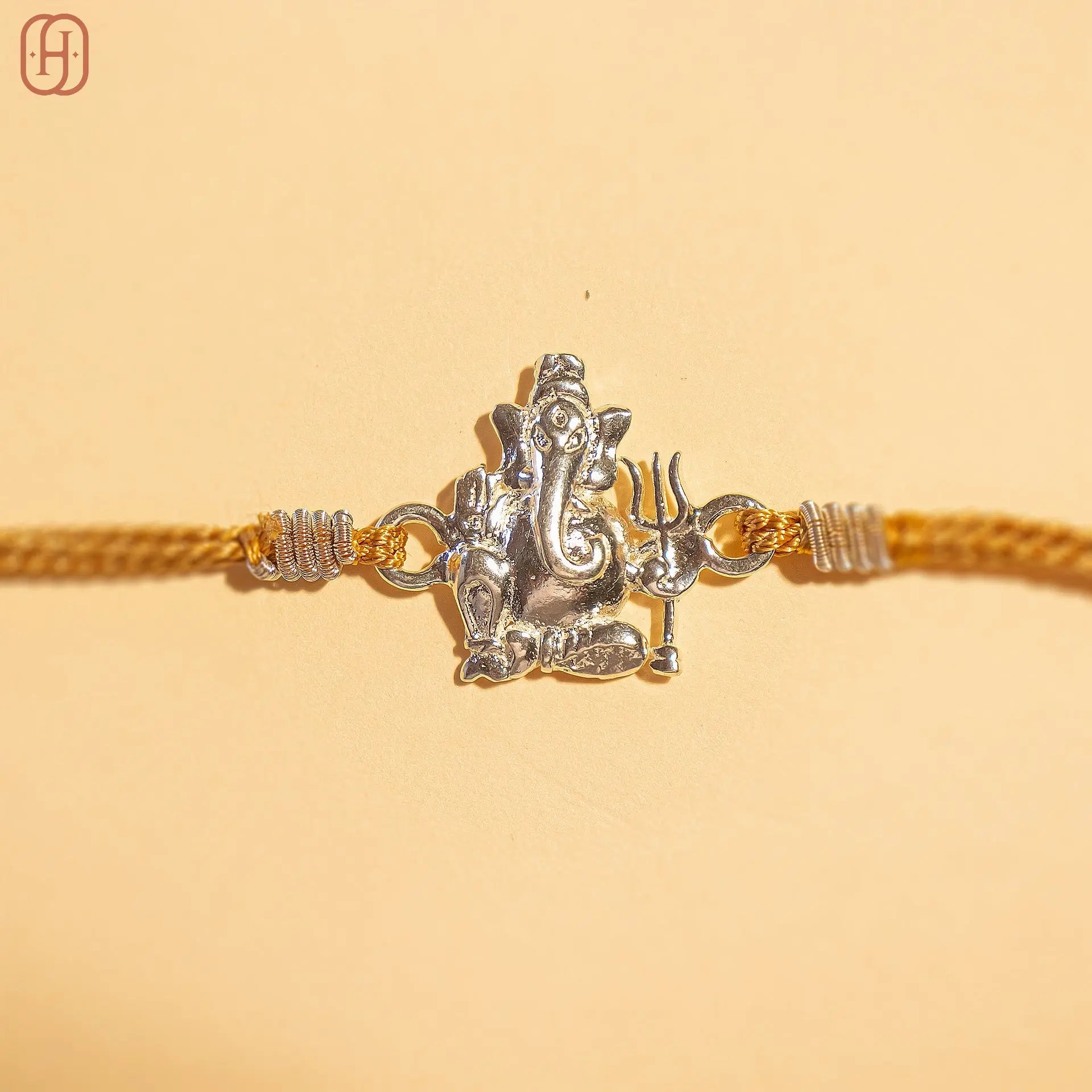 Ganesh silver rakhi with detailed Ganesh pendant on golden thread by Hardik Jewels