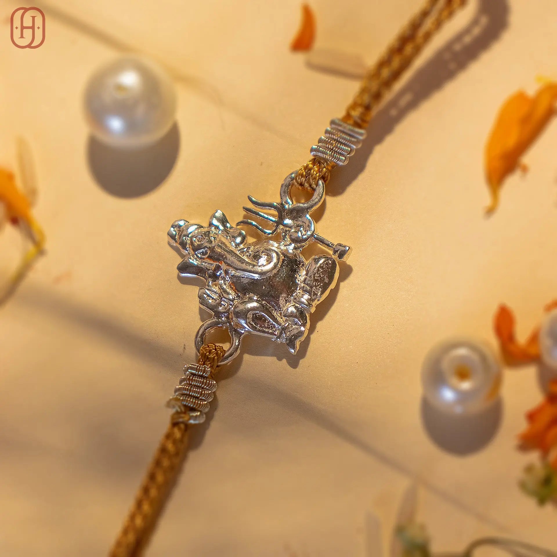 Ganesh silver rakhi with detailed Lord Ganesh charm on brown braided thread from Hardik Jewels
