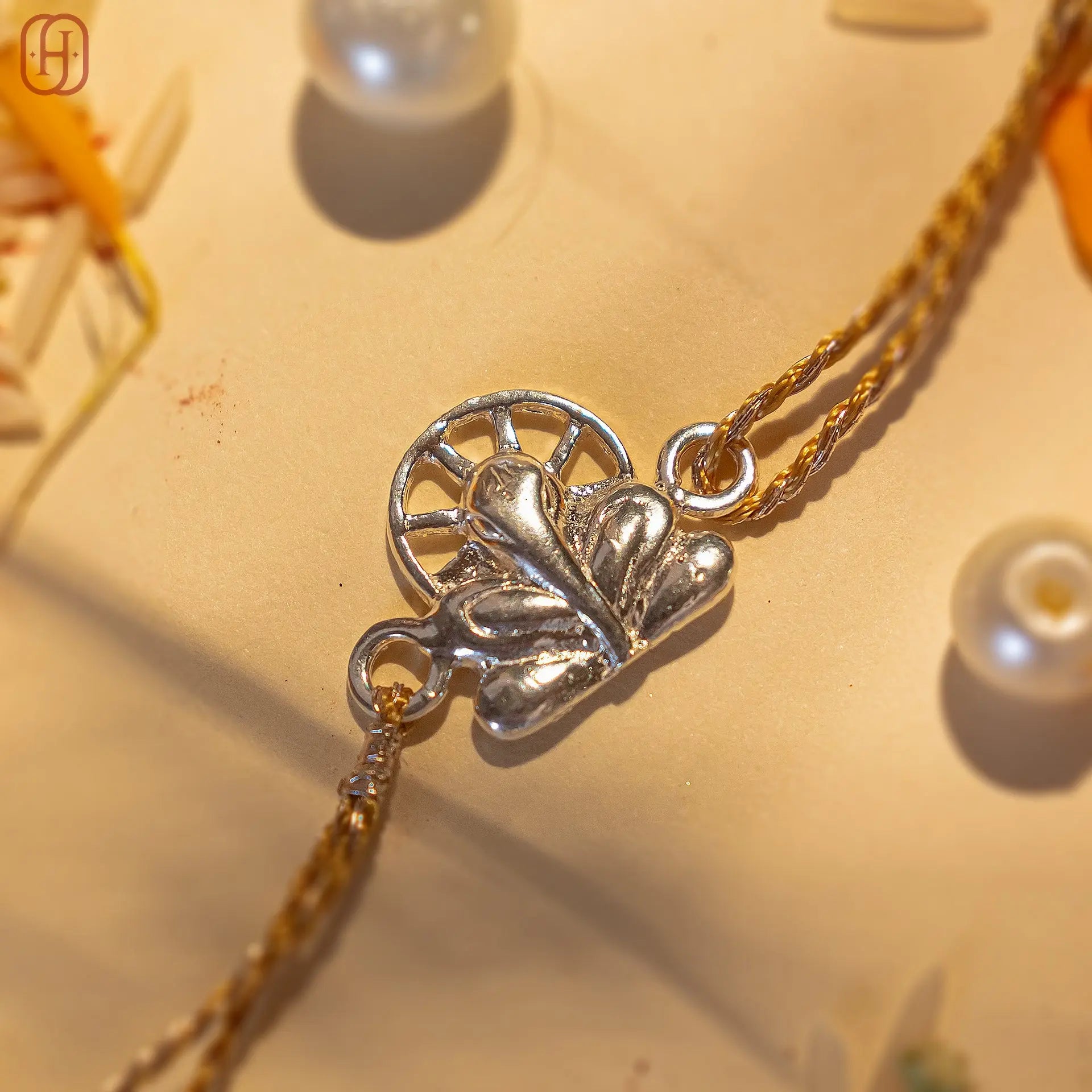 Ganesh silver rakhi online from Hardik Jewels featuring intricate silver Ganesh charm on braided thread