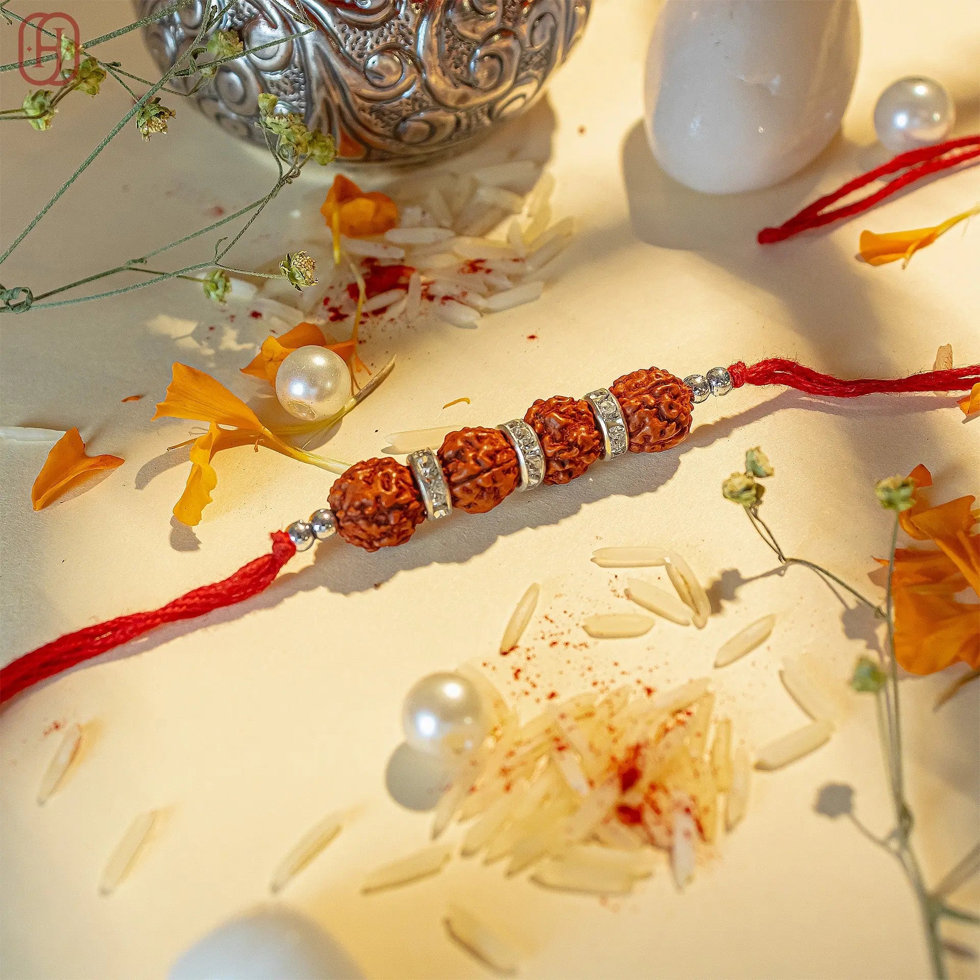 Rudraksha rakhi online with four beads and silver accents on red thread by Hardik Jewels