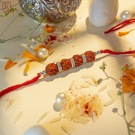 Rudraksha rakhi online with four beads and silver accents on red thread by Hardik Jewels