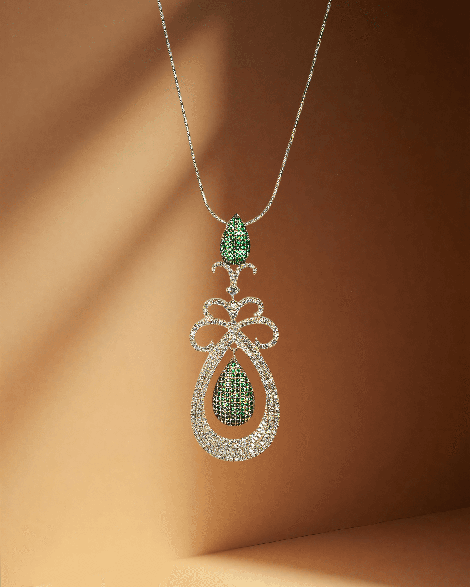 Elegant pendant with a green gemstone pendant on a brown background