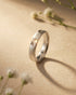 Elegant woman wearing a modern 92.5 sterling silver matte star engraved band ring on her finger.