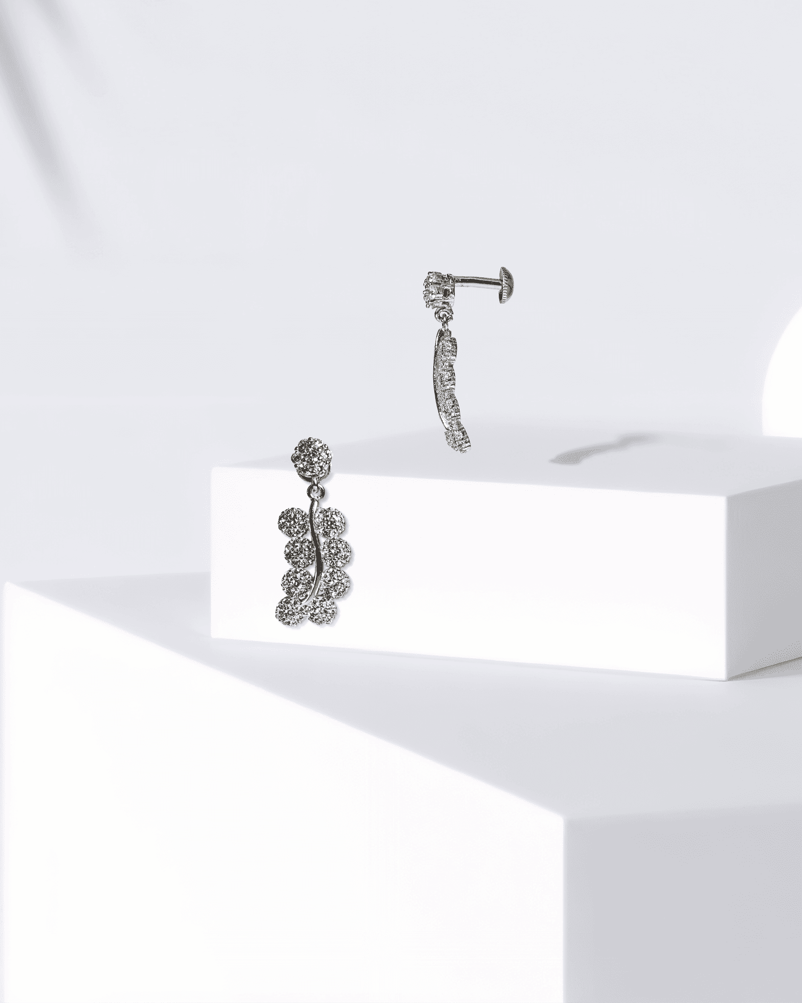 Pair of silver earrings on a white surface