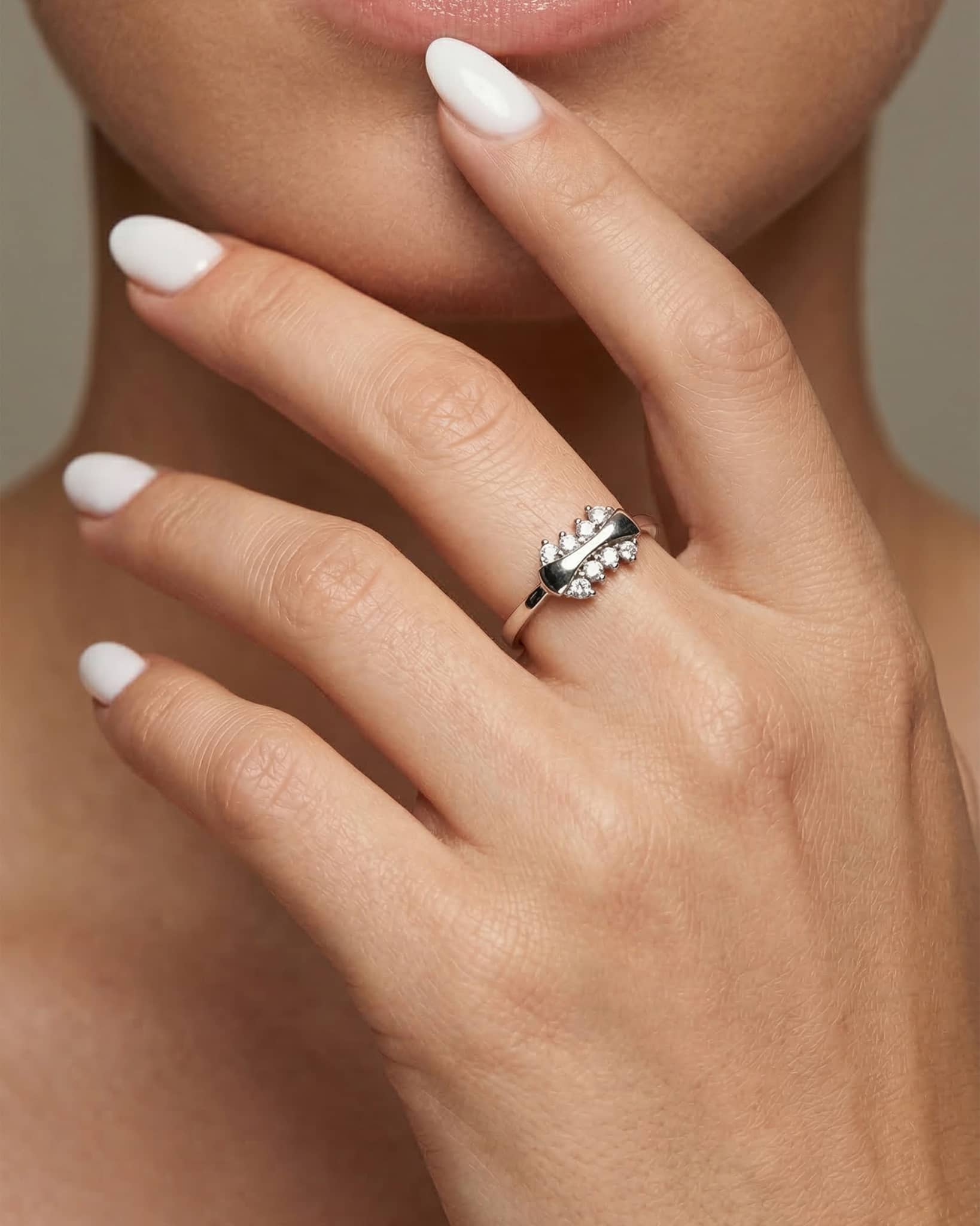 Beautiful woman wearing a delicate 92.5 sterling silver ring with a sleek wavy polished center and sparkling clear cz stones.