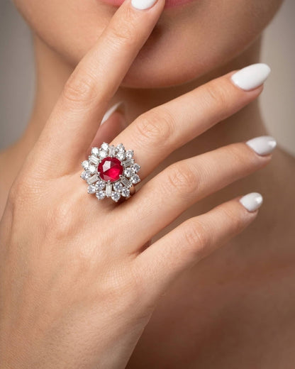 Beautiful woman wearing a stunning 92.5 sterling silver ruby cz cocktail ring featuring a large red center and vintage diamond-cut halo.