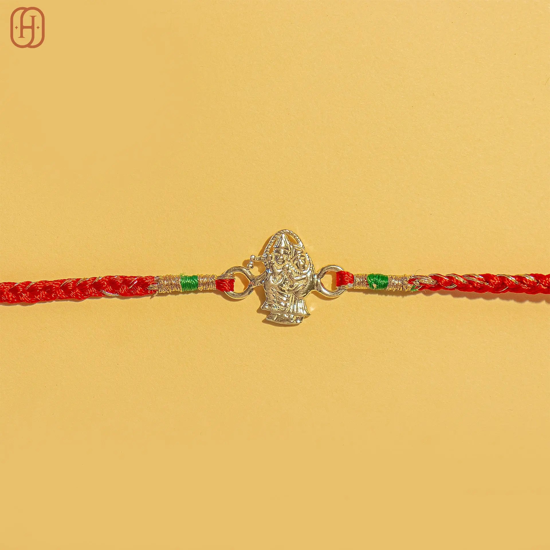 Rakha Krishna silver bracelet rakhi with detailed silver charm and red braided thread by Hardik Jewels