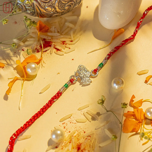 Rakha krishna silver bracelet rakhi with red braided thread and silver Krishna charm by Hardik Jewels