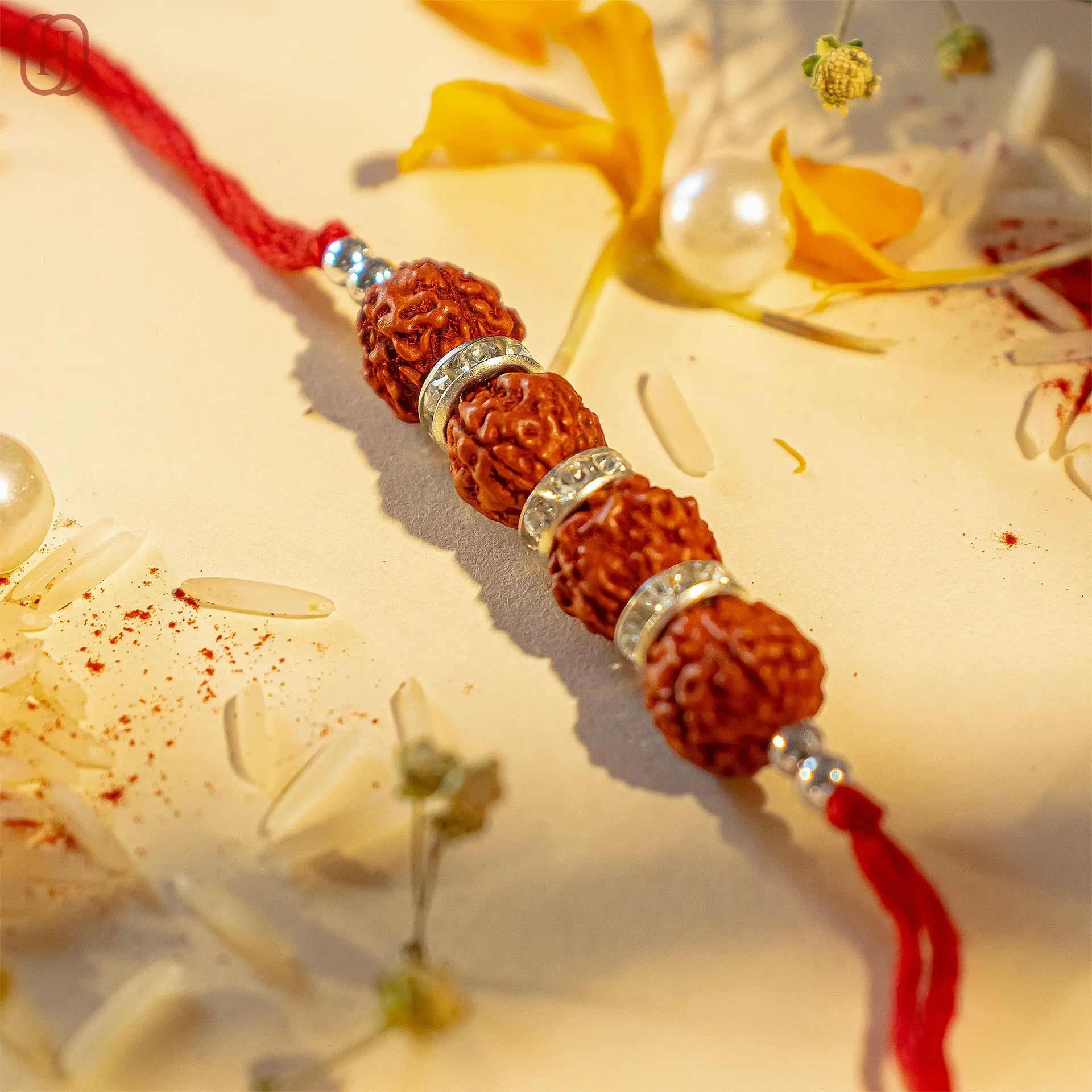 Rudraksha rakhi online with natural beads and silver accents on a red thread from Hardik Jewels
