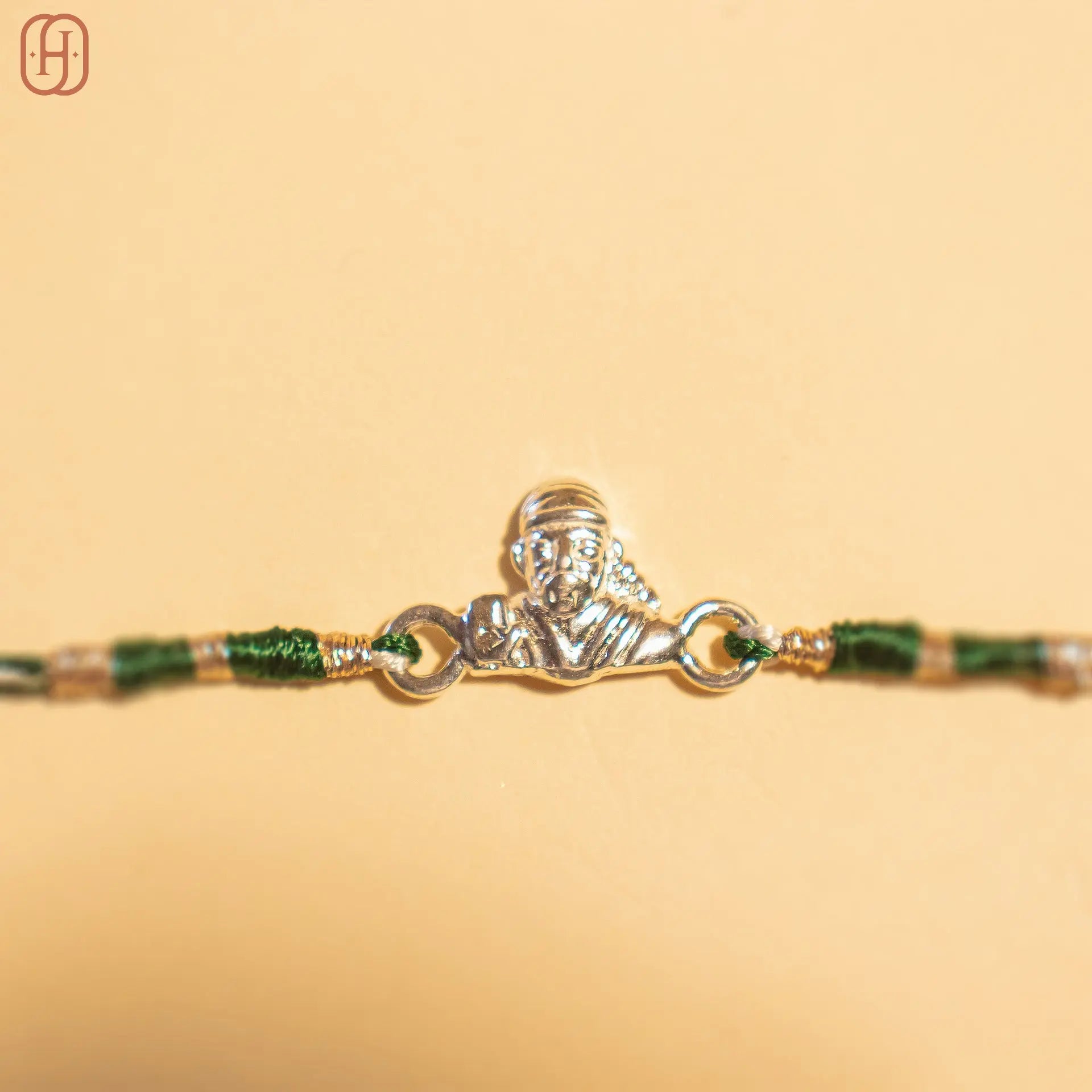 Sai Baba silver rakhi with detailed silver charm and green thread from Hardik Jewels