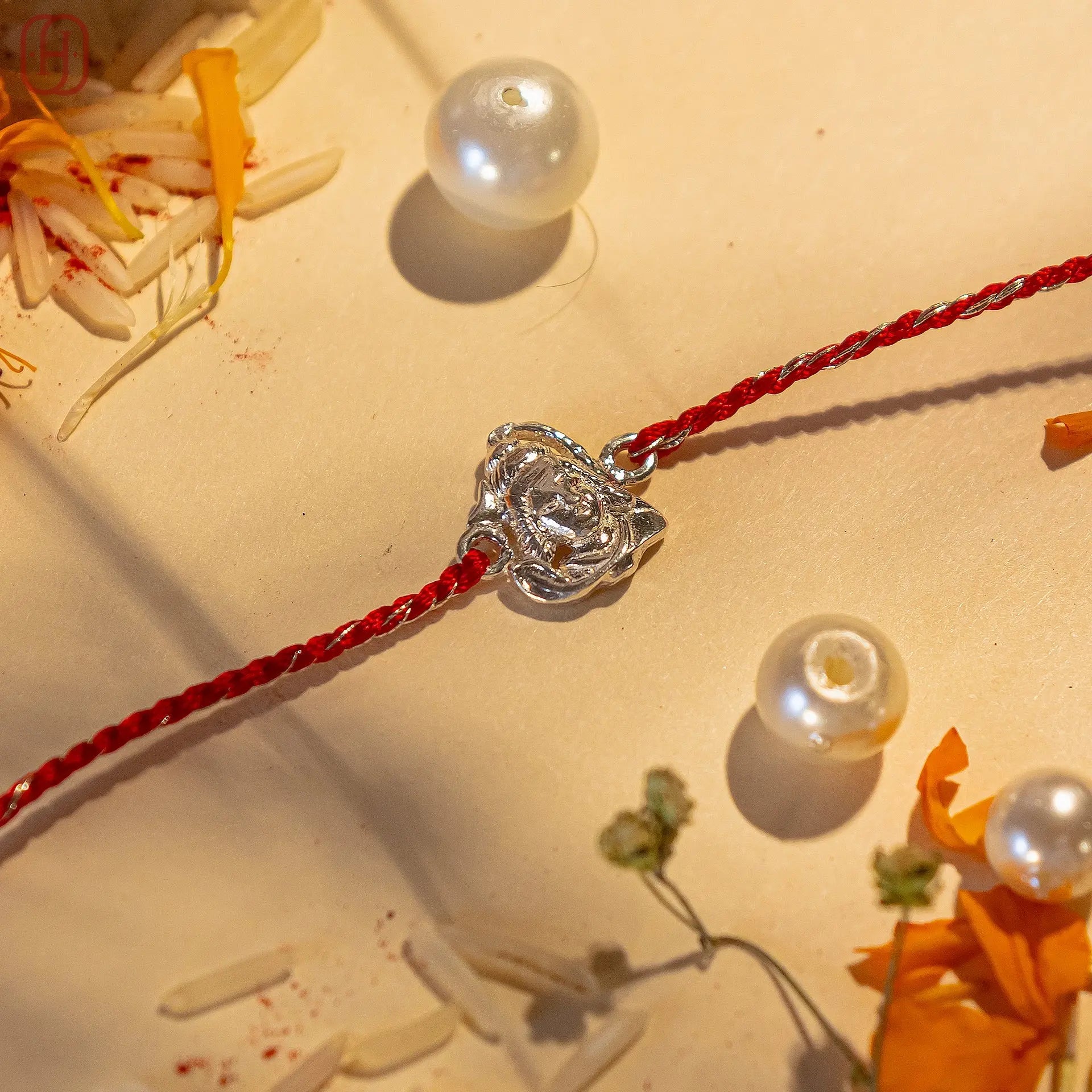 Shiv ji silver rakhi online with a detailed silver centerpiece on a red thread by Hardik Jewels