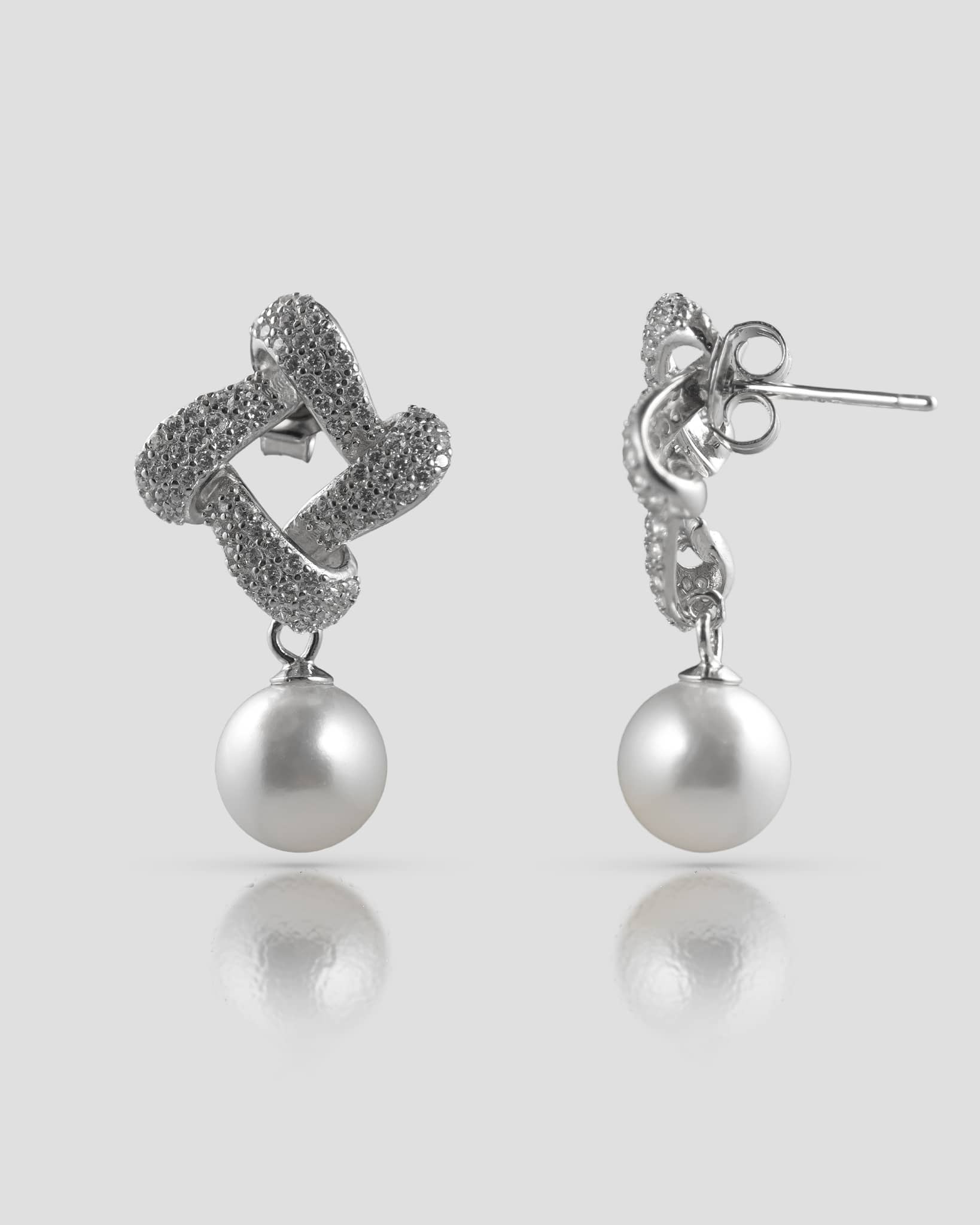 Front and back profile view of silver twisted knot pearl drop earrings showing the push-back closure.