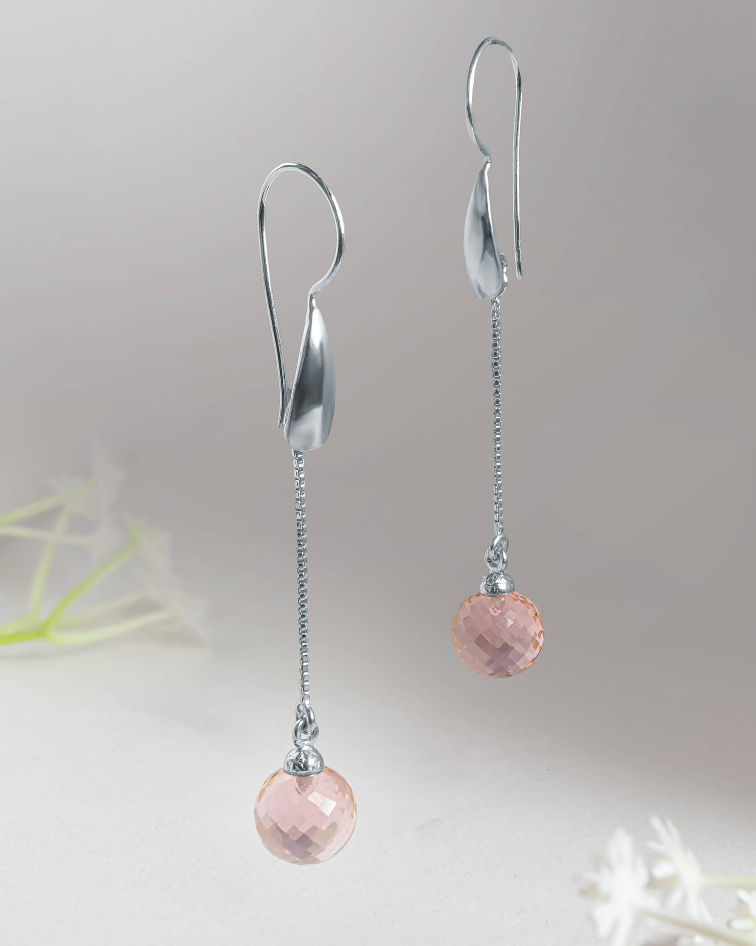 Front and back profile view of silver long chain drop earrings showcasing the curved silver hook, delicate chain, and faceted pink stone.