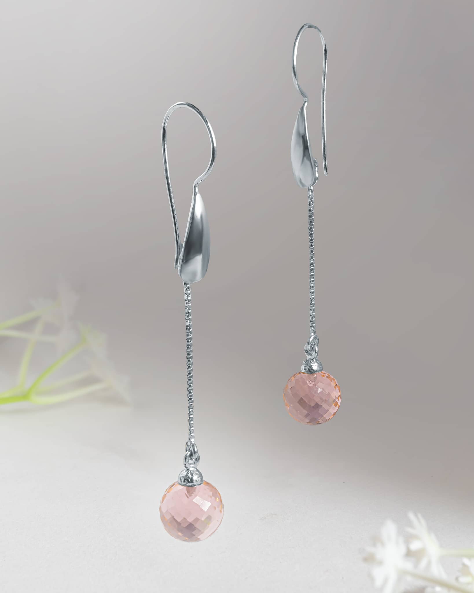 Front and back profile view of silver long chain drop earrings showcasing the curved silver hook, delicate chain, and faceted pink stone.