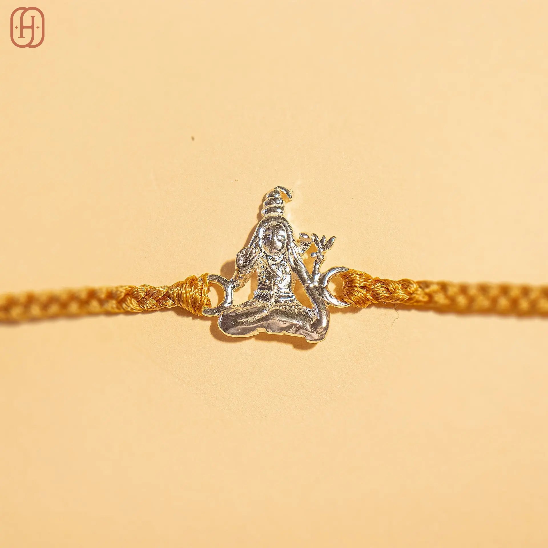 Unique Shiva rakhi for brothers with silver Shiva charm on a golden braided thread by Hardik Jewels