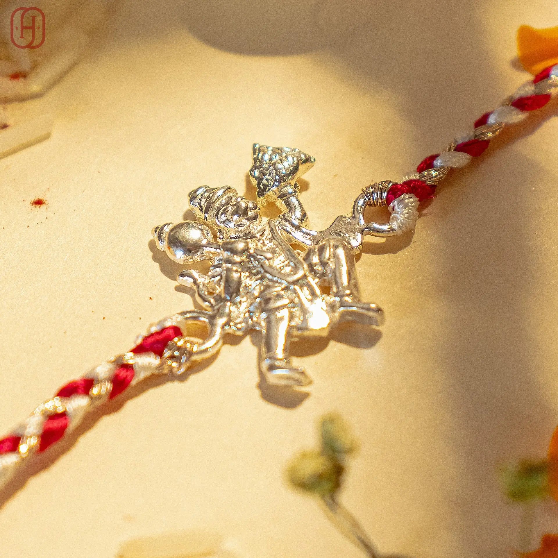 92.5 silver hanuman rakhi with detailed Hanuman charm on red and white braided thread by Hardik Jewels